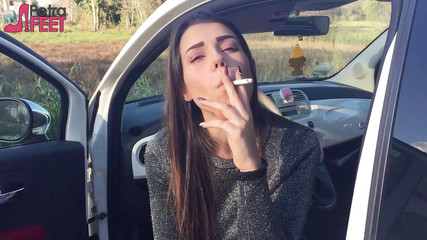 Gorgeous babe smokes a cigar outdoors