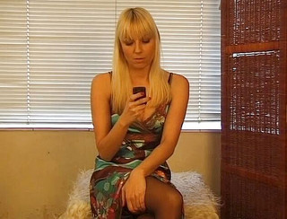 Cute blonde girl is talking on the phone and playing with her tits